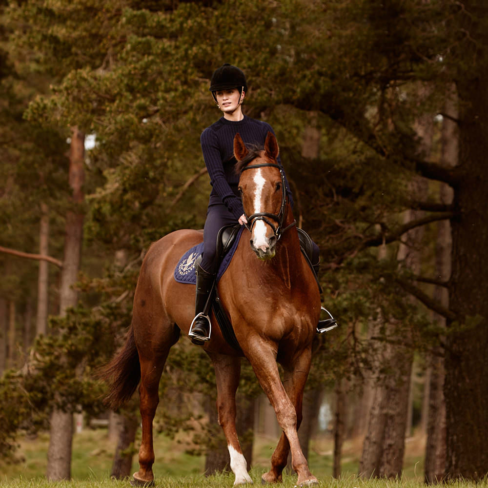A rider on horseback next to some woods at Gleneagles