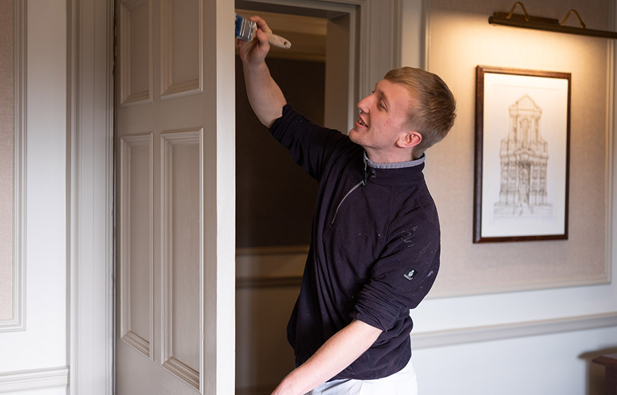 A painter paints the door of a bedroom at Gleneagles