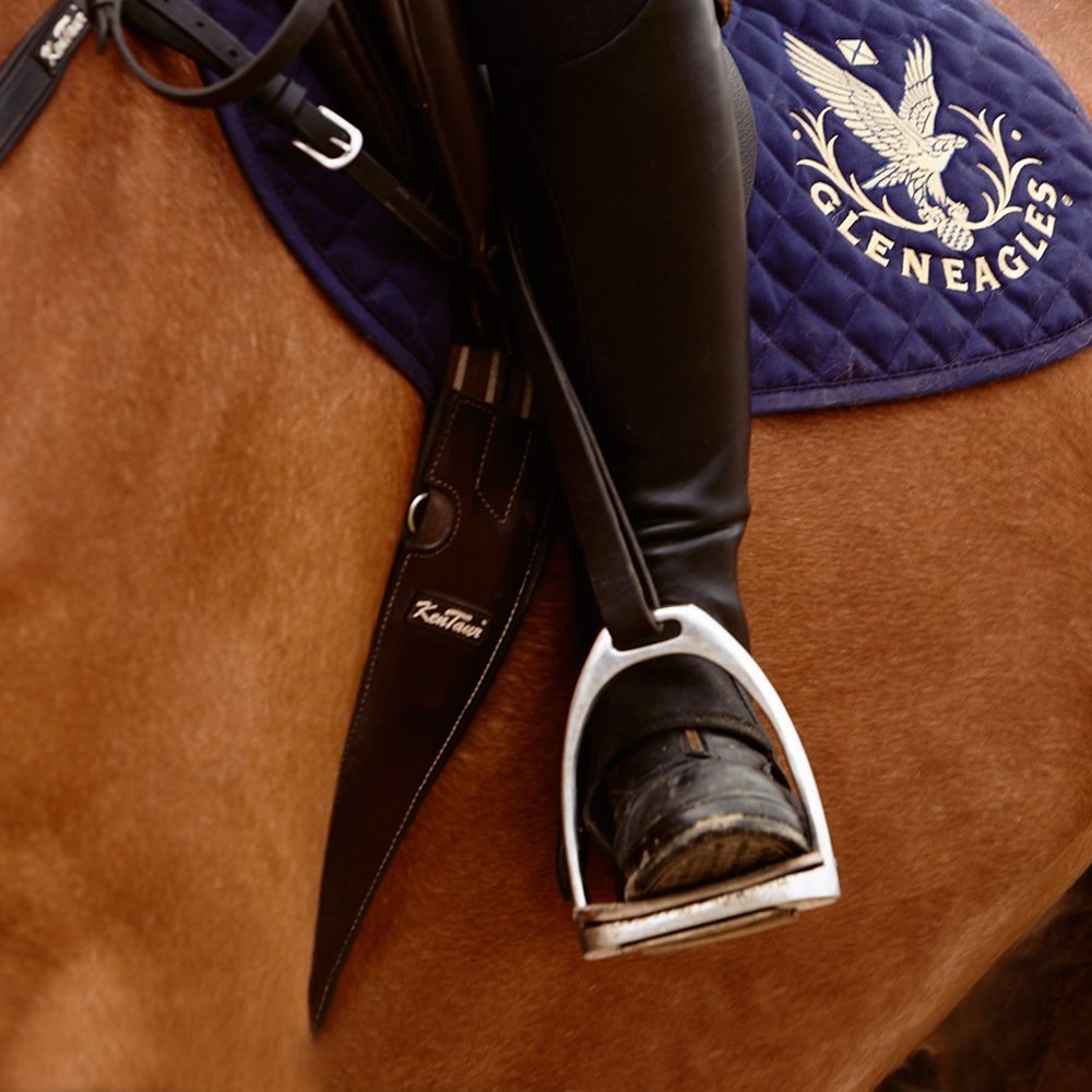 A riders boot in a stirrup with Gleneagles branded numnah