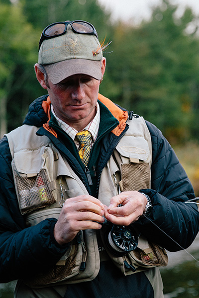 A fisherman tying a fly