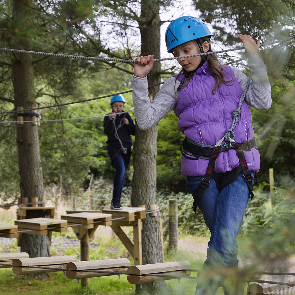 A young girl makes her way along a low ropes course at Gleneagles