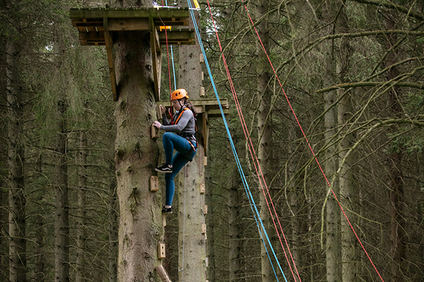 A woman climbing to the zip wiring platform at Gleneagles