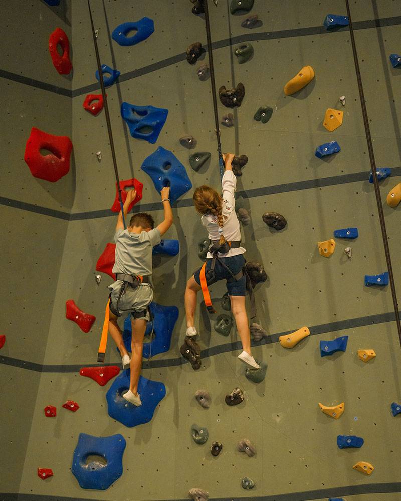 Young boy and young girl on climbing wall