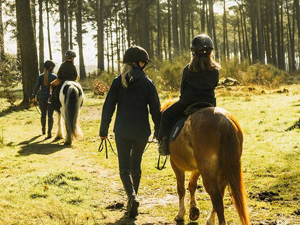 Children horse riding through woodland at Gleneagles estate