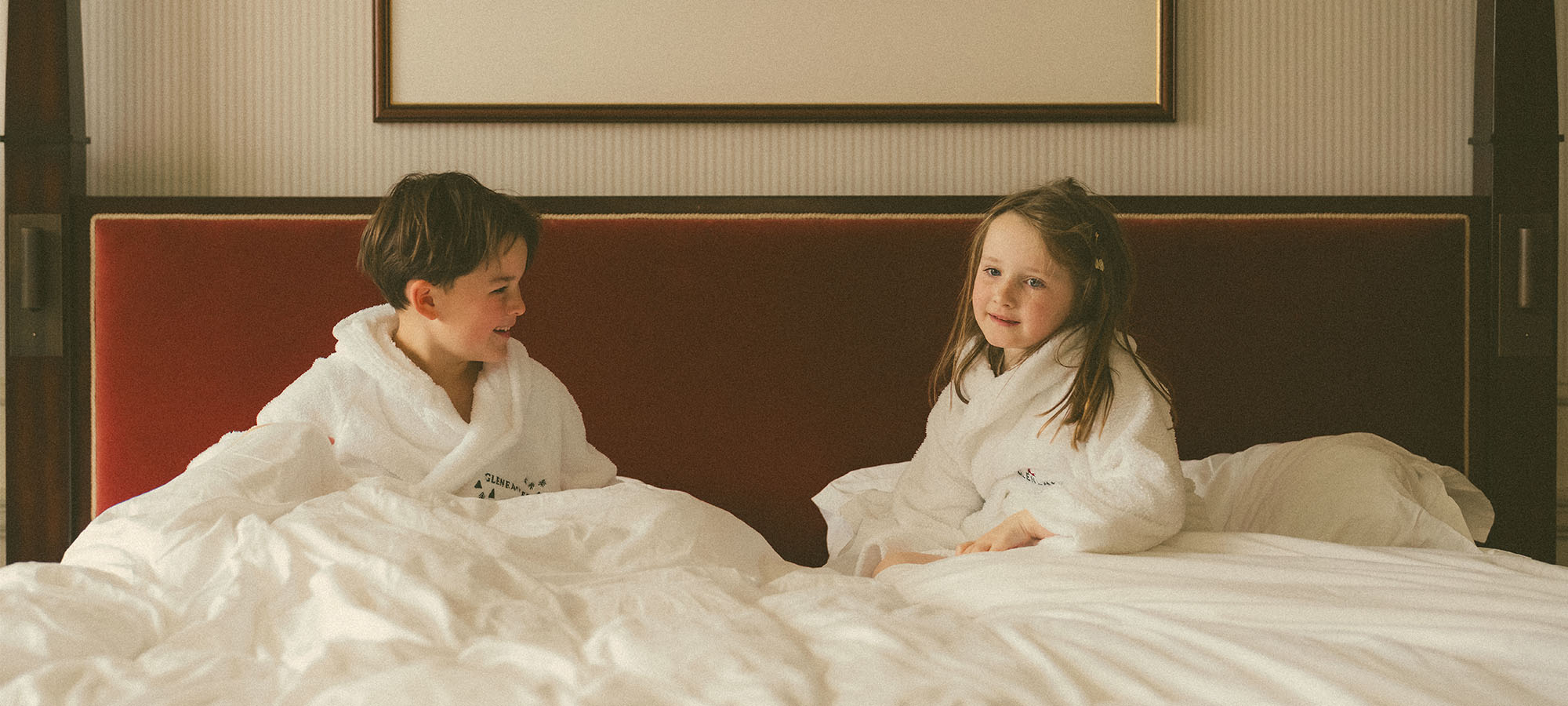 Two young children wearing Gleneagles robes, ready for bed