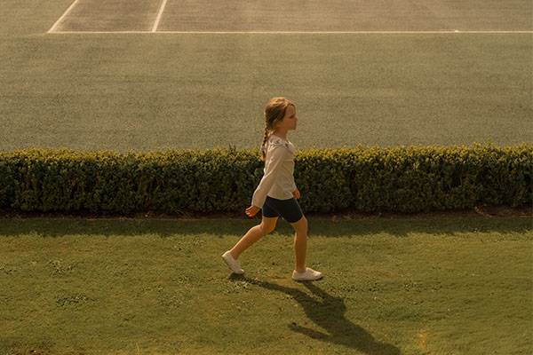 Young girl casually walking on Gleneagles Tennis court
